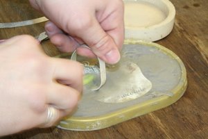 scrubbing silver hoop with pumice powder to remove any copper streaks/discolouration